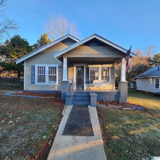 view of front facade with covered porch and a front yard