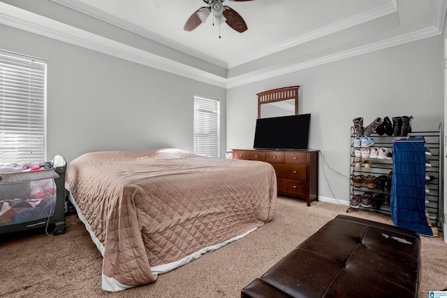 bedroom with ceiling fan, light colored carpet, crown molding, and a tray ceiling