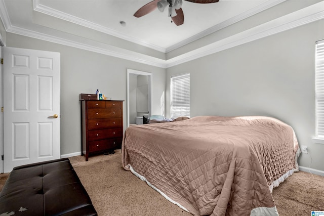 bedroom with ceiling fan, carpet floors, crown molding, and a tray ceiling