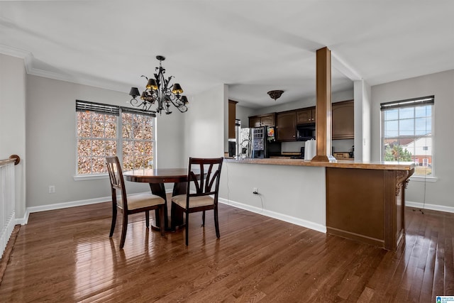 dining room with ornamental molding, dark wood-type flooring, and a chandelier