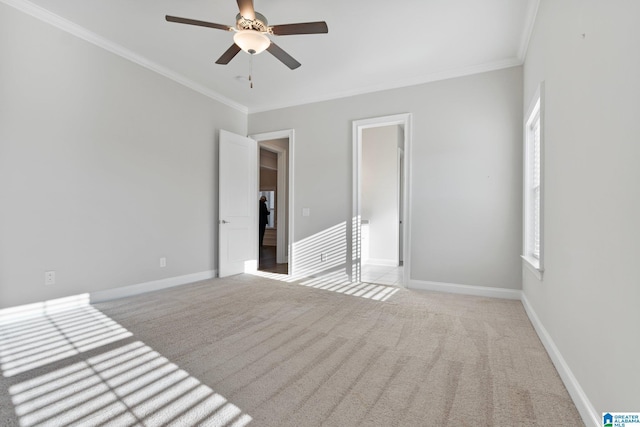 carpeted spare room featuring ceiling fan and crown molding