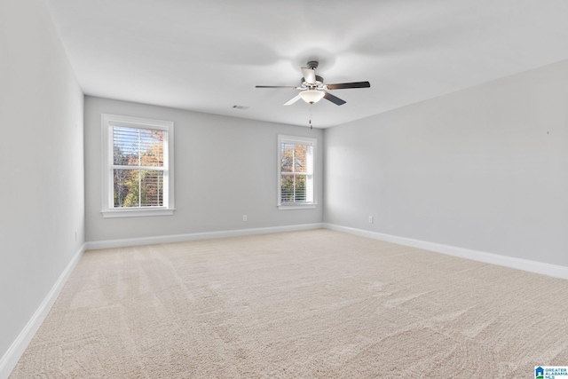 spare room featuring light carpet and ceiling fan