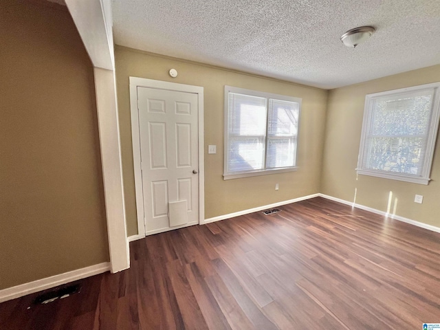 entryway featuring dark hardwood / wood-style flooring and a textured ceiling