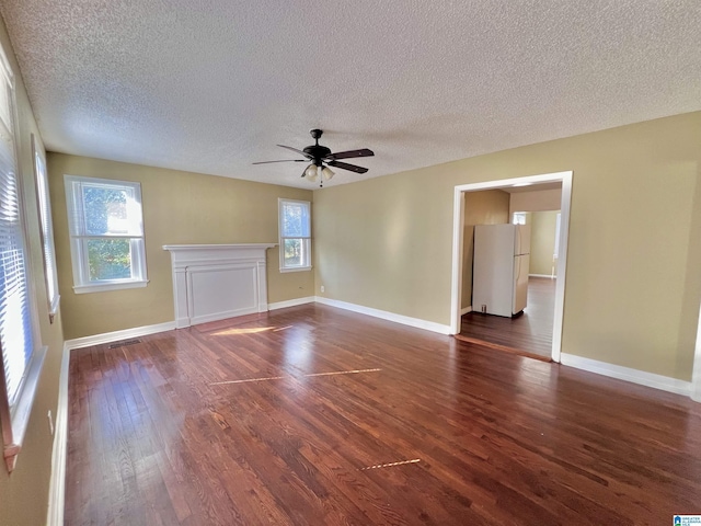 spare room featuring a textured ceiling, ceiling fan, and dark wood-type flooring