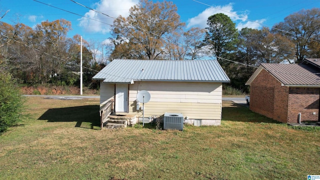 view of outdoor structure featuring a yard and central air condition unit