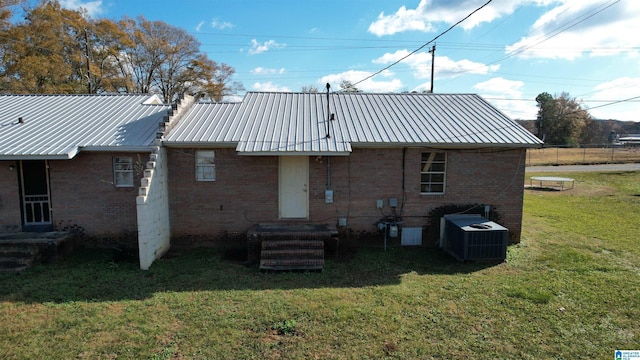 back of house with a yard and central AC unit