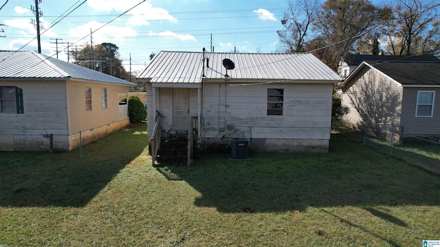 rear view of property featuring a yard and central air condition unit