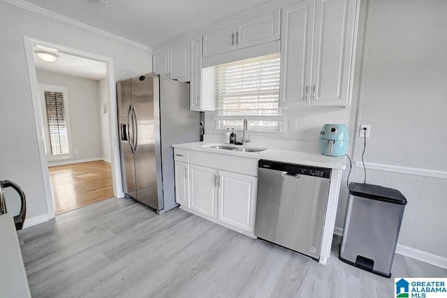 kitchen with white cabinetry, sink, stainless steel appliances, and light hardwood / wood-style floors