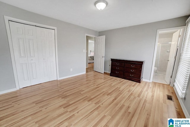 unfurnished bedroom with connected bathroom, a closet, and light hardwood / wood-style floors