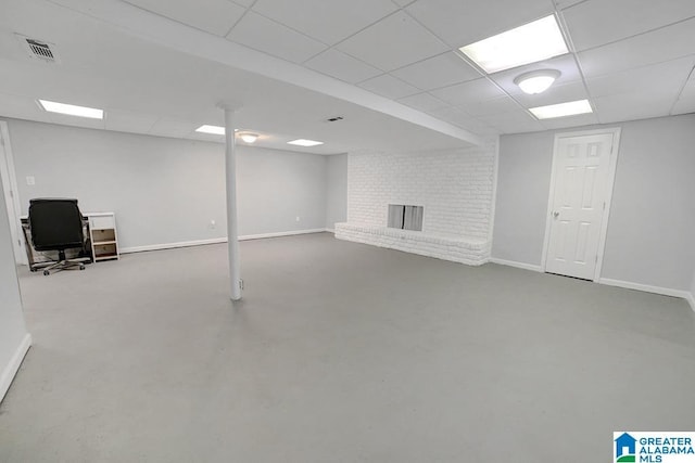 basement featuring a paneled ceiling and a fireplace