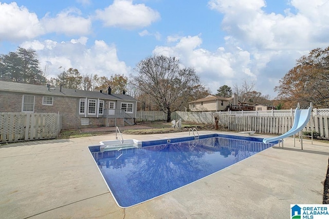 view of pool featuring a diving board, a patio, and a water slide