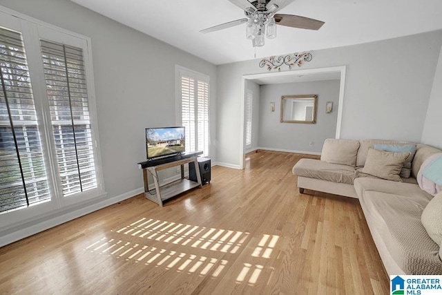 living room with ceiling fan, plenty of natural light, and light hardwood / wood-style flooring