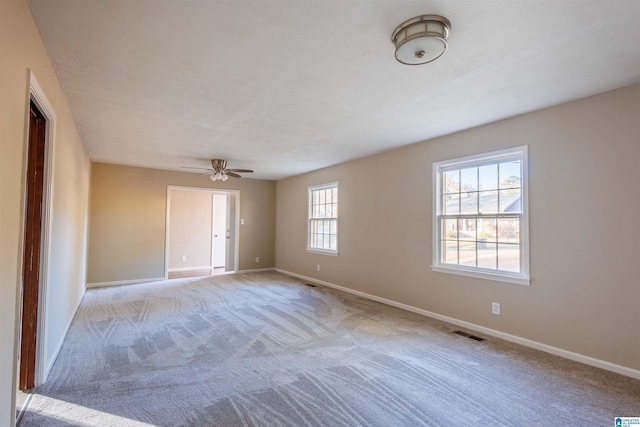 carpeted empty room featuring ceiling fan and a textured ceiling