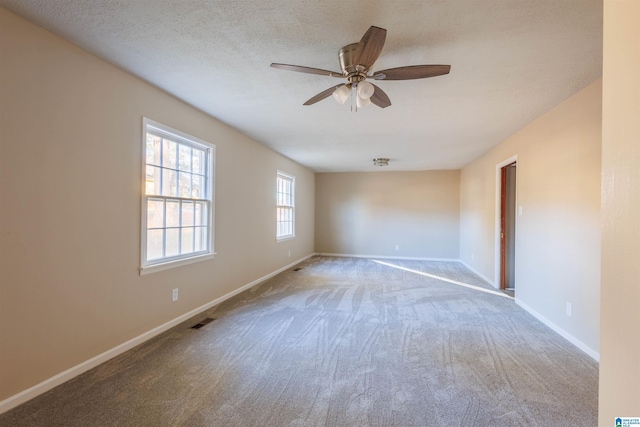 carpeted empty room featuring ceiling fan and a textured ceiling