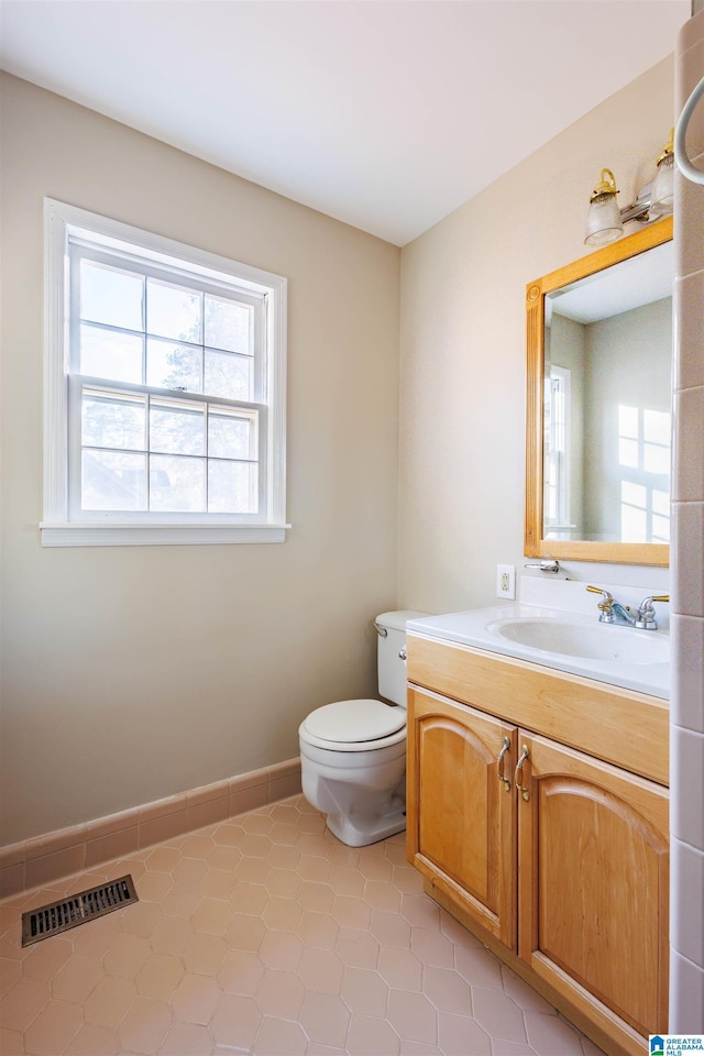 bathroom featuring tile patterned flooring, vanity, and toilet