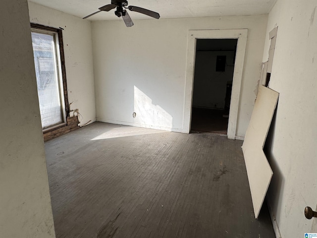 unfurnished room with hardwood / wood-style floors, electric panel, and ceiling fan