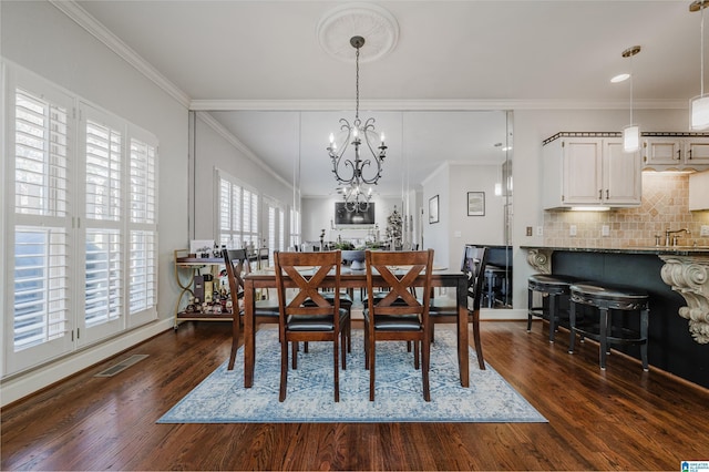 dining room featuring dark hardwood / wood-style floors, an inviting chandelier, and ornamental molding