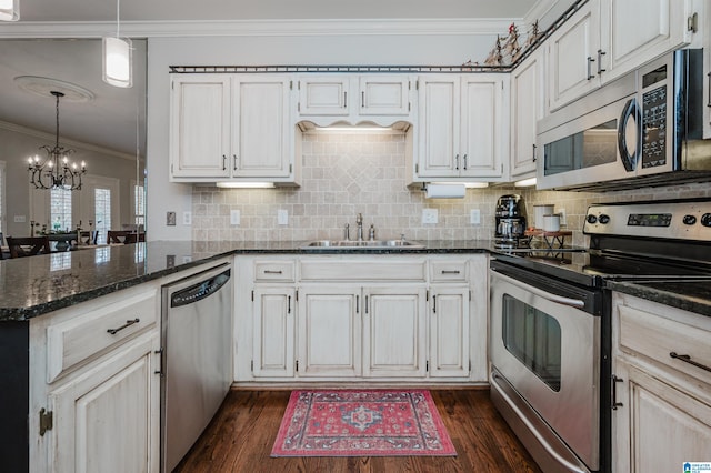 kitchen with dark hardwood / wood-style flooring, stainless steel appliances, sink, an inviting chandelier, and white cabinetry