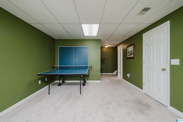 recreation room featuring a paneled ceiling and light colored carpet