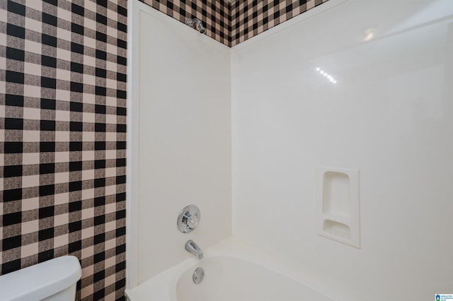 bathroom featuring toilet and washtub / shower combination