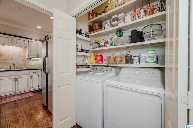 laundry area with separate washer and dryer, sink, dark wood-type flooring, and ornamental molding