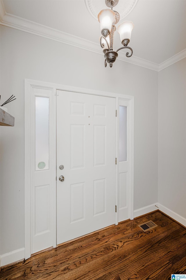 foyer with dark hardwood / wood-style flooring, crown molding, and a notable chandelier