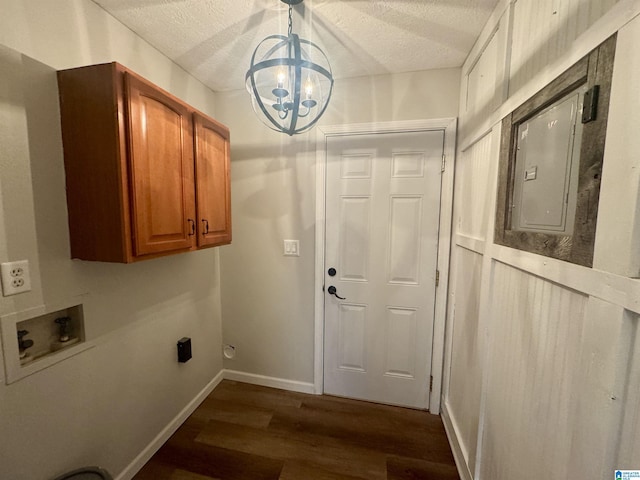 clothes washing area featuring cabinets, dark wood-type flooring, electric panel, hookup for a washing machine, and a chandelier