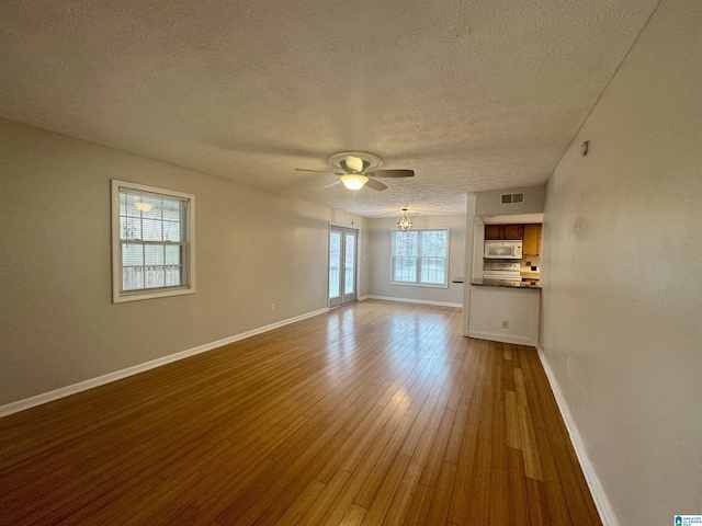 unfurnished living room featuring ceiling fan, wood-type flooring, and a textured ceiling