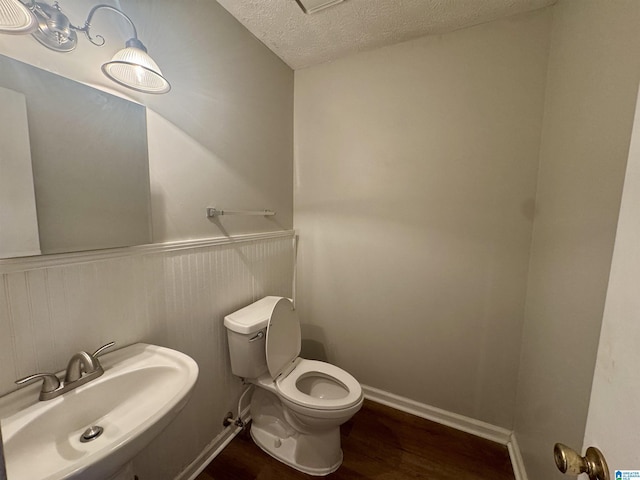 20708 Honeysuckle Ln, Mccalla, AL 35111 - bathroom featuring wood finished floors, a textured ceiling, and a wainscoted wall