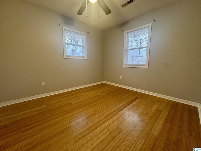 spare room featuring hardwood / wood-style flooring, ceiling fan, and a wealth of natural light