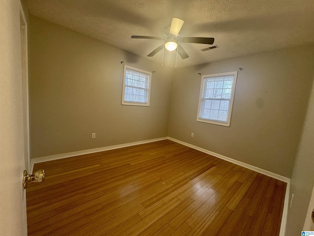 empty room with hardwood / wood-style floors, a textured ceiling, and ceiling fan