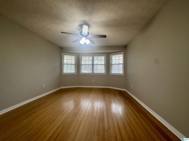 spare room with ceiling fan, wood-type flooring, and a textured ceiling