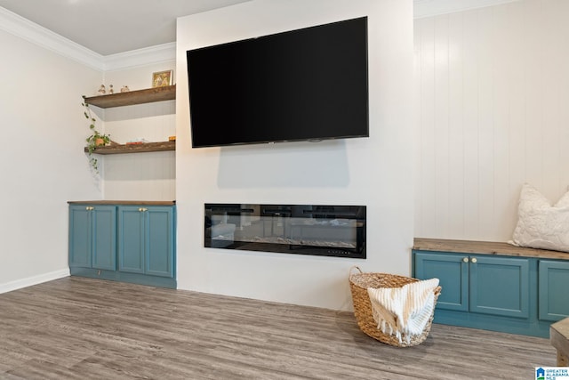 unfurnished living room with crown molding and hardwood / wood-style floors