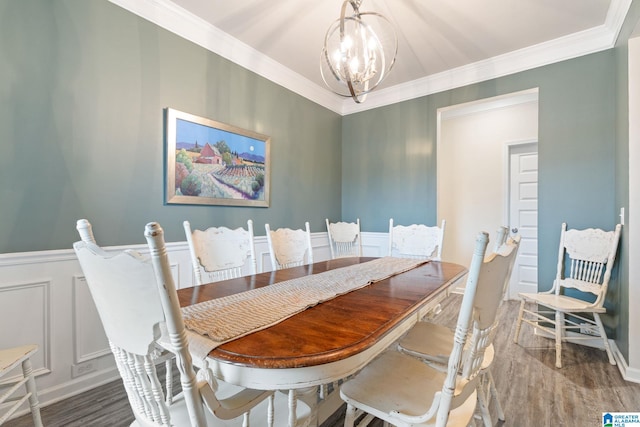 dining room with dark hardwood / wood-style flooring, ornamental molding, and an inviting chandelier