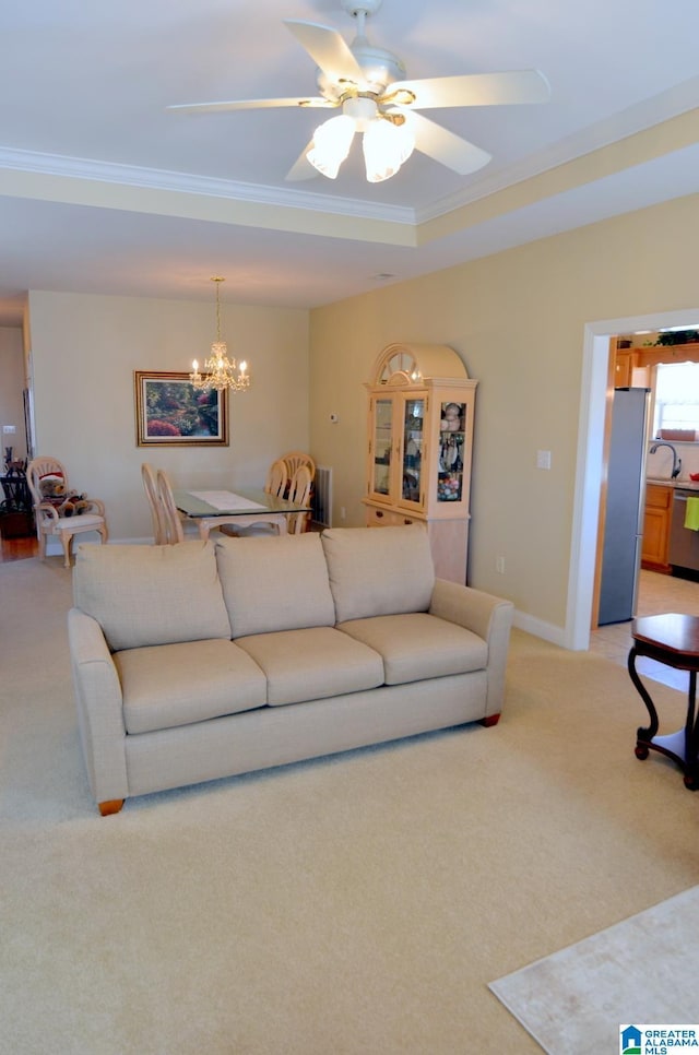 living room featuring carpet flooring, sink, ceiling fan with notable chandelier, and ornamental molding