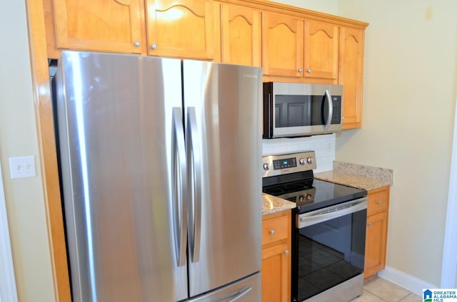 kitchen featuring decorative backsplash, light stone countertops, light tile patterned floors, and stainless steel appliances