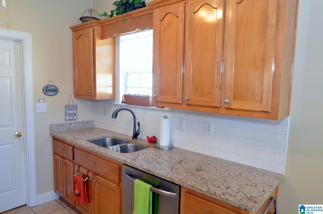 kitchen featuring dishwasher, light stone counters, sink, and tasteful backsplash