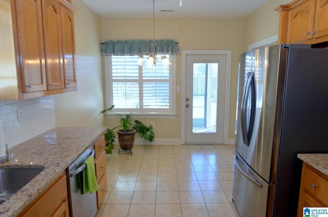 kitchen with hanging light fixtures, an inviting chandelier, backsplash, light tile patterned flooring, and appliances with stainless steel finishes