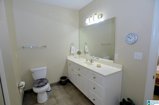 bathroom with toilet, vanity, and tile patterned floors