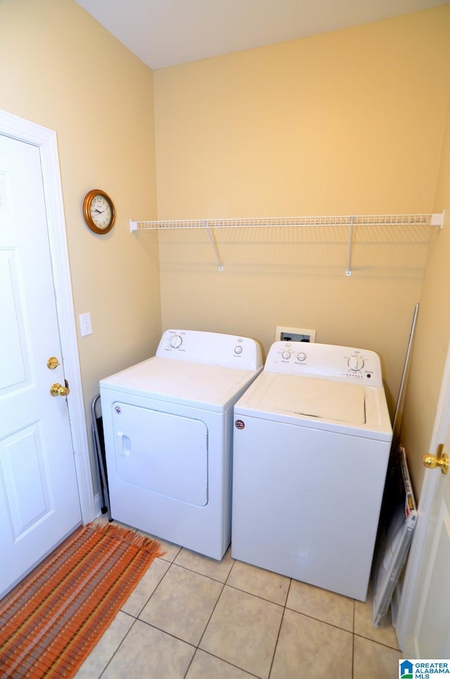 laundry room featuring washer and dryer and light tile patterned floors