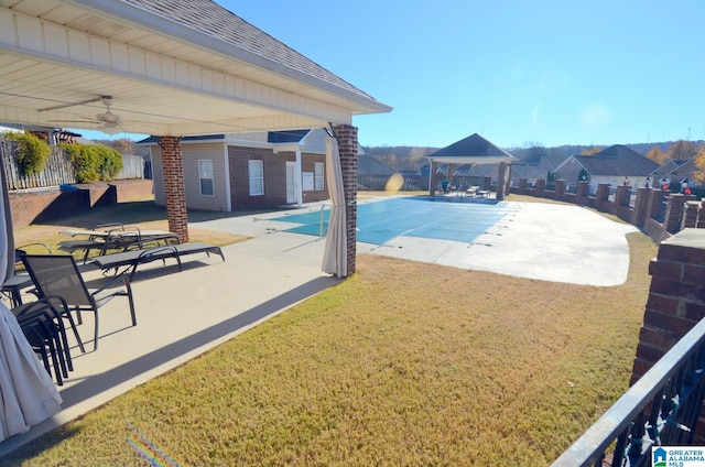 view of pool with a gazebo, ceiling fan, a yard, and a patio