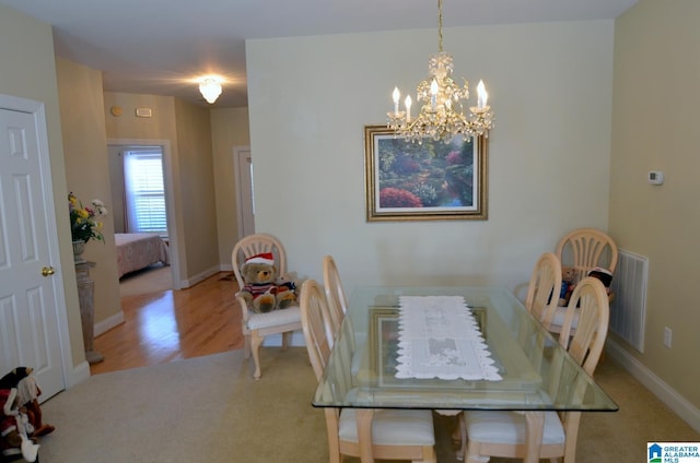 dining space with a chandelier and light hardwood / wood-style floors