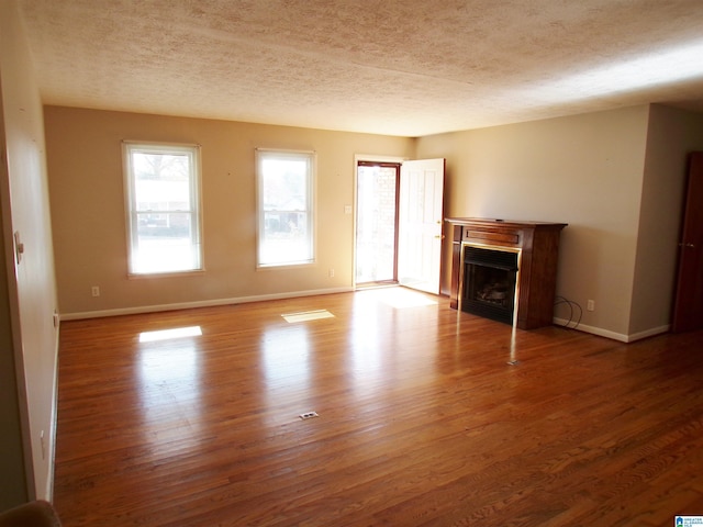 unfurnished living room featuring a textured ceiling and hardwood / wood-style flooring