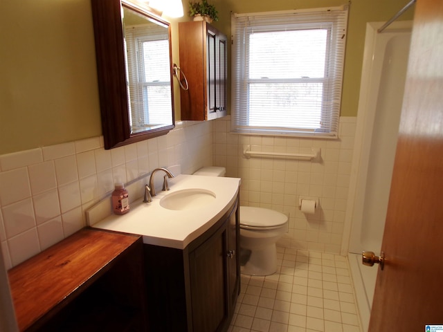 bathroom with tile patterned floors, plenty of natural light, and tile walls