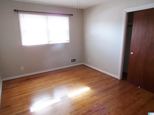 unfurnished bedroom featuring light hardwood / wood-style flooring and a closet