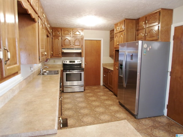 kitchen with sink, stainless steel appliances, and a textured ceiling