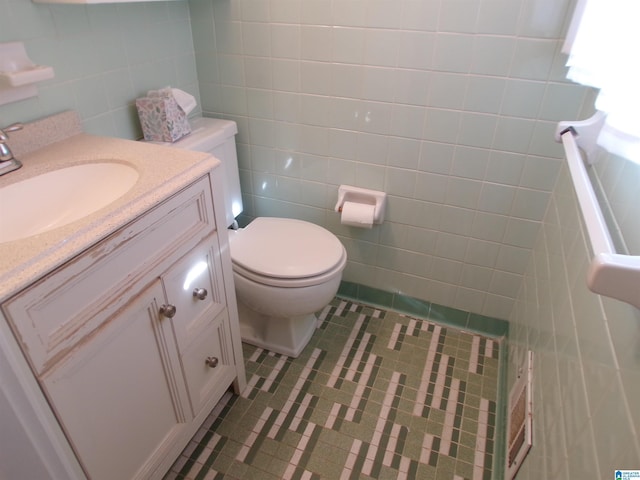 bathroom featuring vanity, tile walls, and toilet