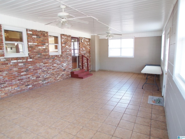 spare room with light tile patterned flooring and brick wall