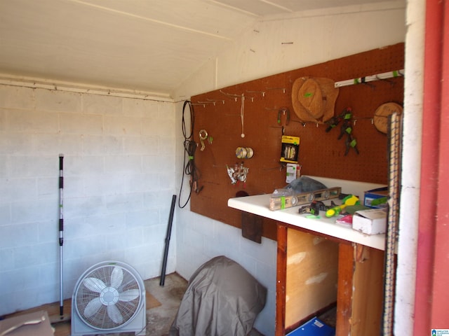 miscellaneous room featuring concrete floors and vaulted ceiling