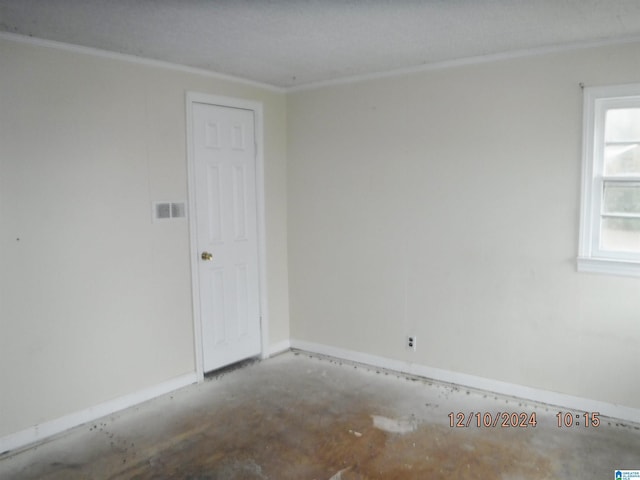 spare room with a textured ceiling and ornamental molding